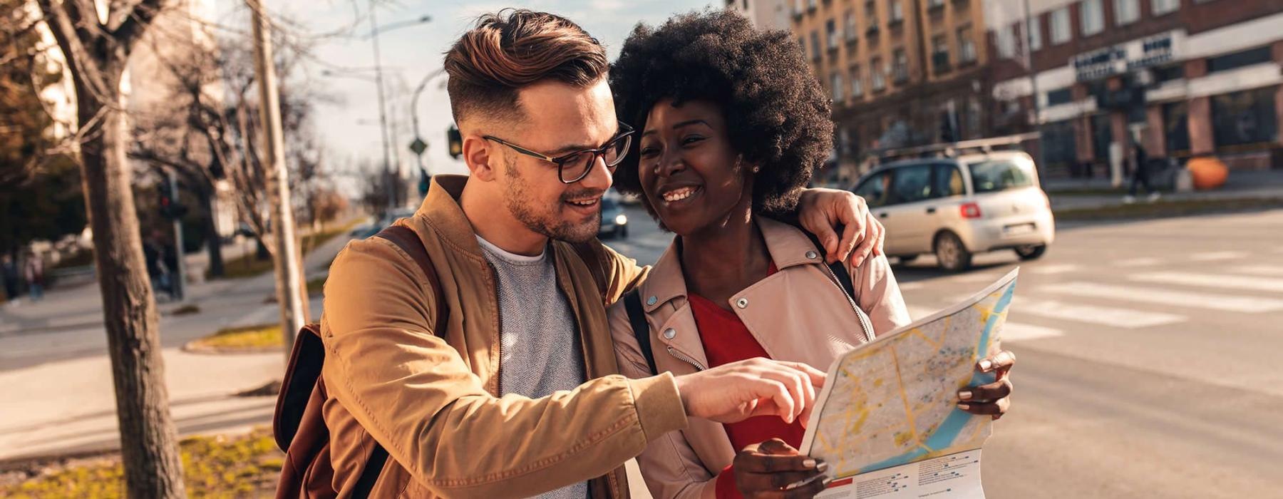 a man and woman looking at a map in the city