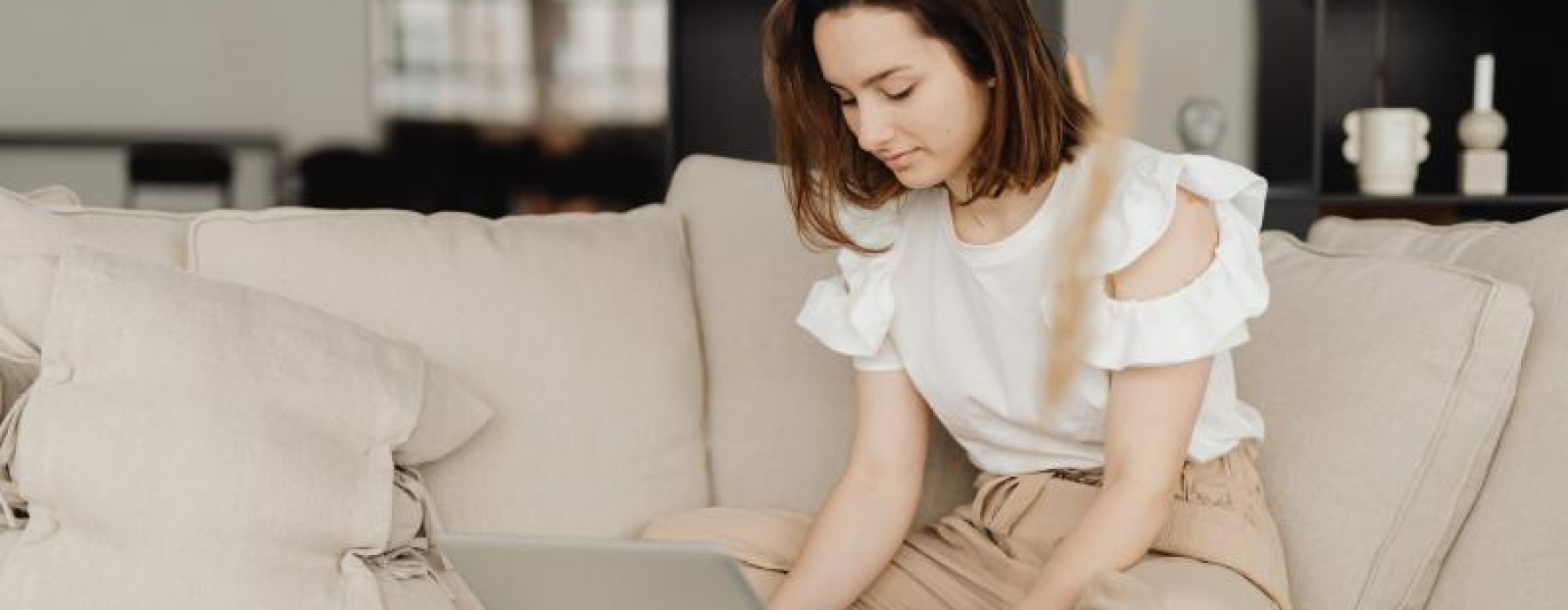 a person sitting on a couch using a laptop